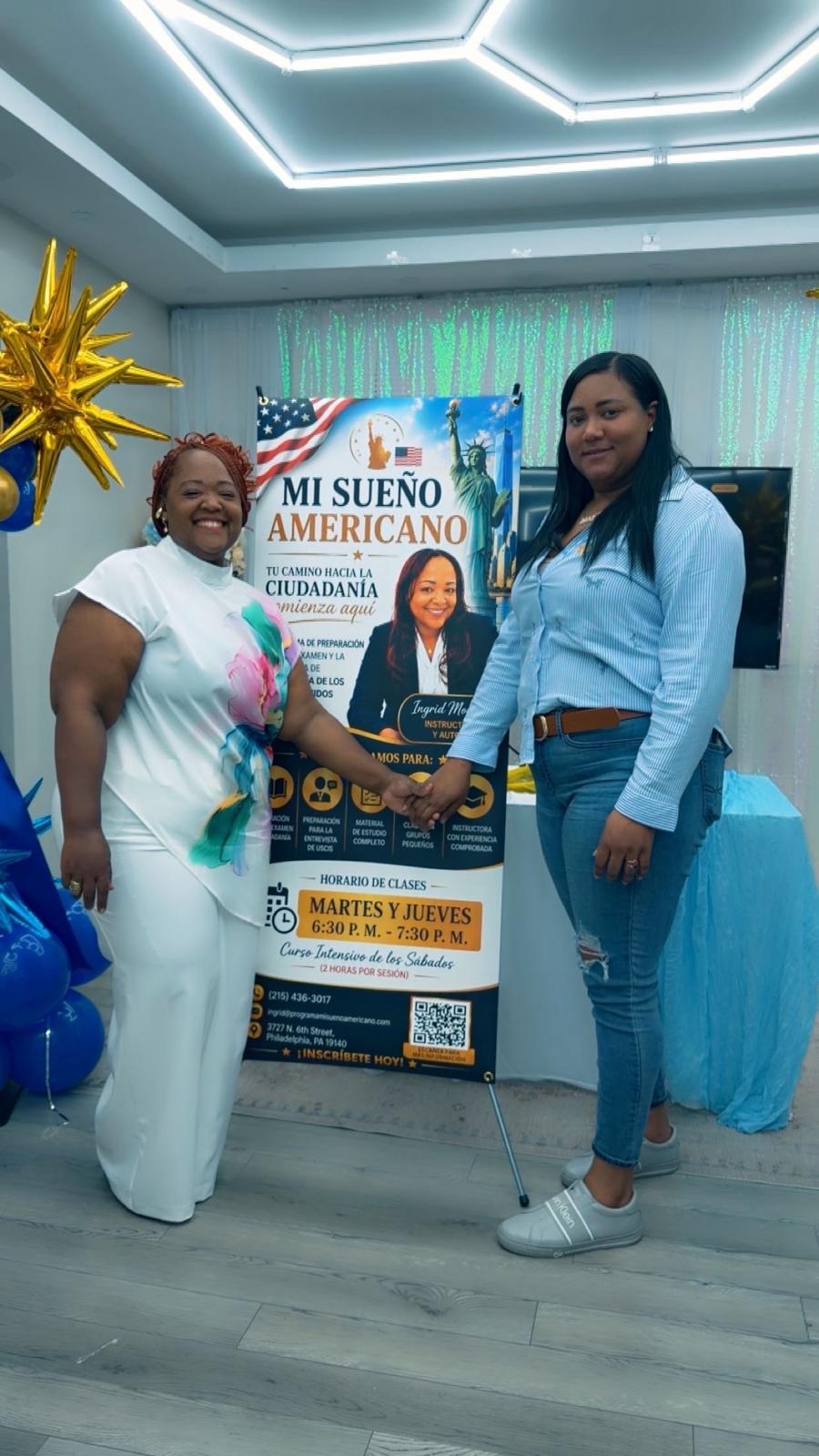 Ingrid Morales junto a una asistente frente al afiche del programa.
